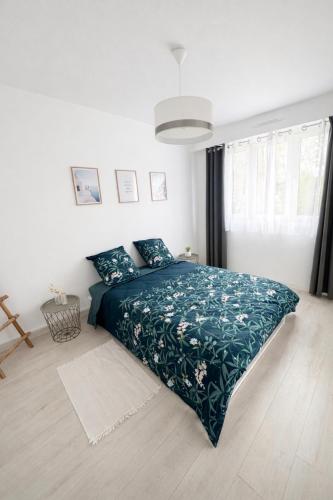 a bedroom with a bed with a green comforter at Appartement Chilly Mazarin T3 Proche Aéroport Orly in Chilly-Mazarin