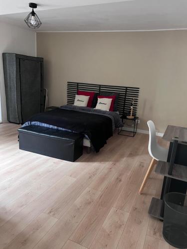 a bedroom with a large bed and a wooden floor at Chez Nath House in Sedan