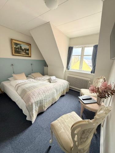 a bedroom with a bed and a table and a chair at Hotel Faaborg in Faaborg