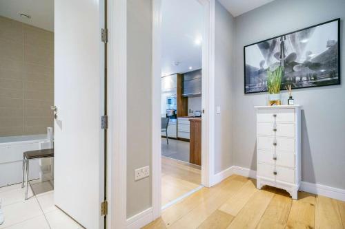 a hallway with a white dresser and a mirror at Luxury & Central 2 Bedroom Ormeau Road Apartment in Belfast