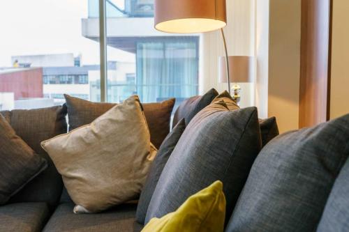 a bunch of pillows on a couch in a living room at Luxury & Central 2 Bedroom Ormeau Road Apartment in Belfast