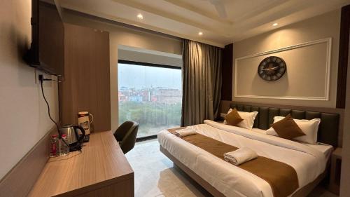a bedroom with a large bed and a window at Hotel Vivaan - Walk to Banke Bihari Temple in Vrindāvan