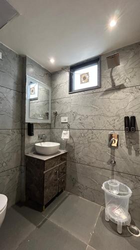 a bathroom with a sink and a toilet and a window at Hotel Vivaan - Walk to Banke Bihari Temple in Vrindāvan