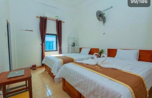 a bedroom with two beds and a laptop on a table at Mountain View Hostel in Bố Trạch