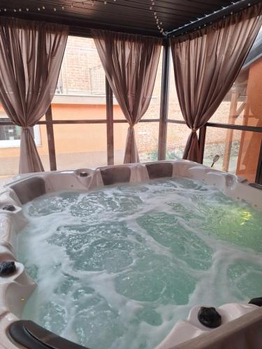 a jacuzzi tub in a room with a window at Holiday&wellness house Grofica in Daruvar