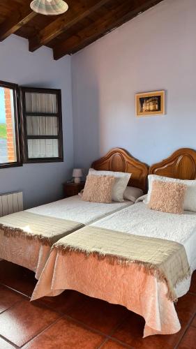 two beds in a room with two bedsitures at Casa de Aldea EL ACEBU in Bierces