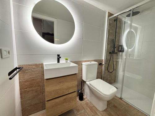 a bathroom with a toilet and a sink and a mirror at Jaén Interior LOFT in Andújar