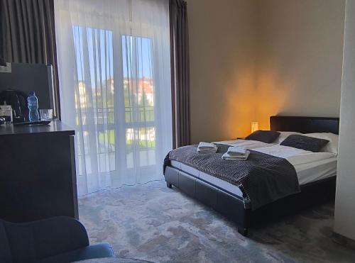 a bedroom with a bed and a large window at Pensjonat Dolce Vita & SPA in Ustronie Morskie