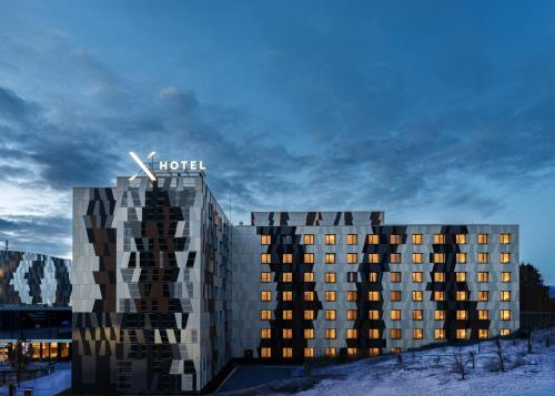 un hôtel avec une horloge au sommet d'un bâtiment dans l'établissement X Hotel, à Skjetten