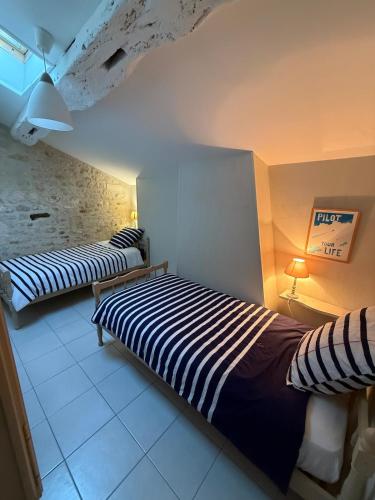 a bedroom with two beds in a room at Gîte à la campagne in Meursac
