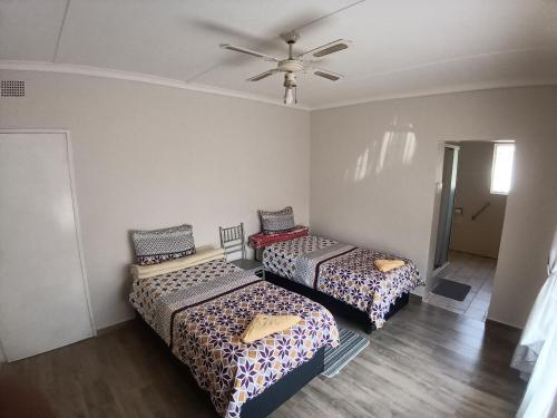 a room with two beds and a ceiling fan at 12 Bologna B&B in Evander