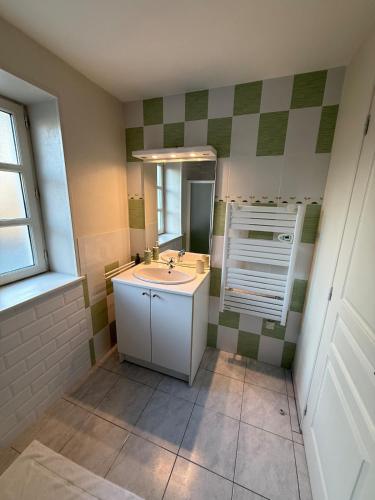 a bathroom with a sink and a mirror at Gîte à la campagne in Meursac