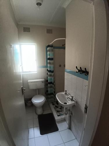a small bathroom with a toilet and a sink at 12 Bologna B&B in Evander
