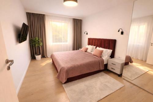 a bedroom with a bed and a mirror at Ran Garden Aparts in Popeşti-Leordeni