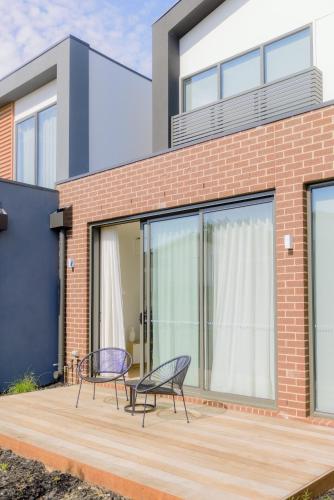 two chairs on a deck in front of a house at Waverley Gardens Modern 3BR Home - Pet Friendly & Parking in Mulgrave