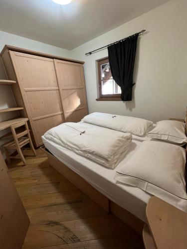 a bedroom with a large bed and a window at Chalet Rin da Pemont in Livigno