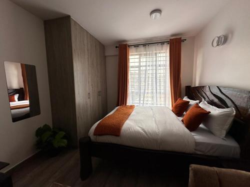 a bedroom with a bed and a window at Joto House in Muchatha