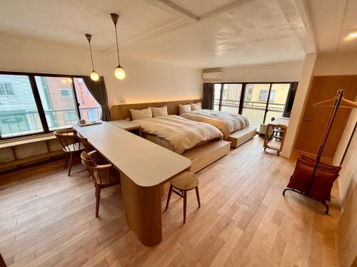 a bedroom with a bed and a table in it at ゲストハウス弓と糸 Guesthouse Yumi To Ito 2F in Nagano