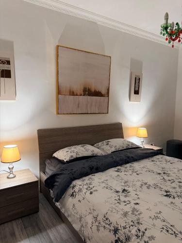 a bedroom with a bed with two lamps and a picture on the wall at Room in sliema's heart in Il-Gżira