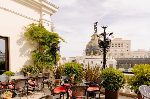 a patio with tables and chairs and a view of the city at The Principal Madrid, Small Luxury Hotels in Madrid