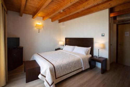 a bedroom with a large bed and two lamps at Tenuta Molino dei Sassi in Zevio