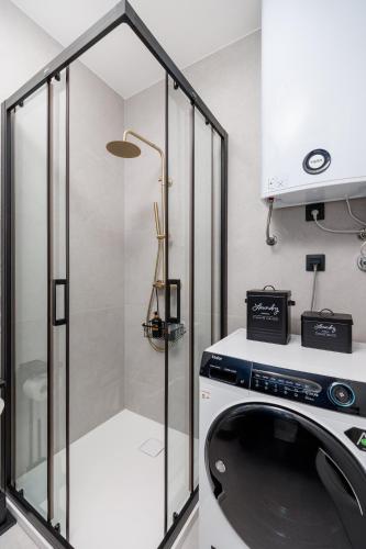a washing machine in a bathroom with a shower at Euphoria Animar & Tiema in Draga Bašćanska