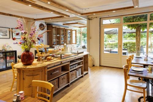 a kitchen with a counter with a table and chairs at Simmerwille B&B- Camping- Bootverhuur in Earnewâld