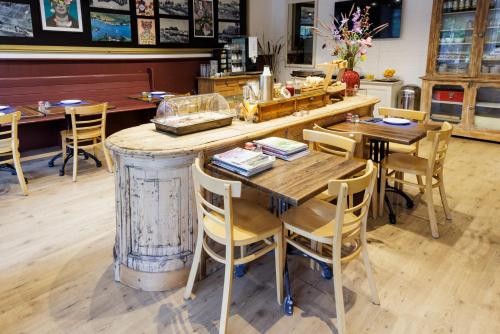 a restaurant with a wooden table and chairs at Simmerwille B&B- Camping- Bootverhuur in Earnewâld