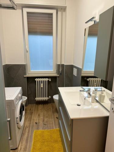 a bathroom with a sink and a washing machine at Maison Regina in Vigevano