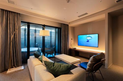 a living room with a couch and a tv at THE skM TOKYO HOTEL & DINING in Tokyo