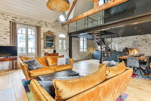 a living room with two couches and a staircase at Welcome to Villa Floréal Your tranquil retreat with spa in Saint-Gilles-Croix-de-Vie
