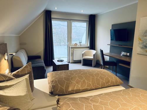 a hotel room with a bed and a desk and a room at Weinbergs Loge in Ernst