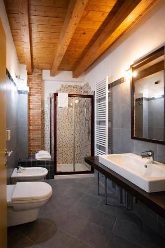 a bathroom with two sinks and a toilet and a shower at Tenuta Molino dei Sassi in Zevio
