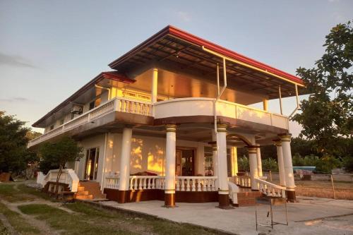 a large house with a porch on a street at Seven Waves Beachfront Residence - La Union in Bagbag Oeste