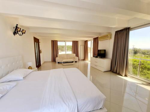 a white bedroom with a large bed and a couch at Le Domaine paradise in Briska Gora