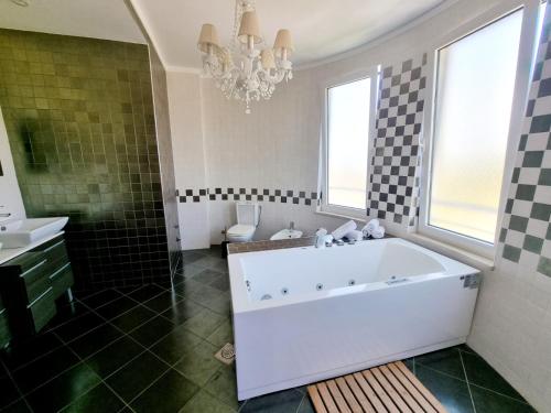 a bathroom with a tub and a sink and a chandelier at Le Domaine paradise in Briska Gora