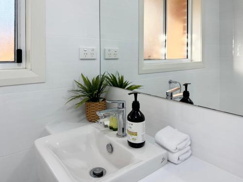 a white bathroom sink with a bottle of wine on it at St Pauls Home in North Wagga