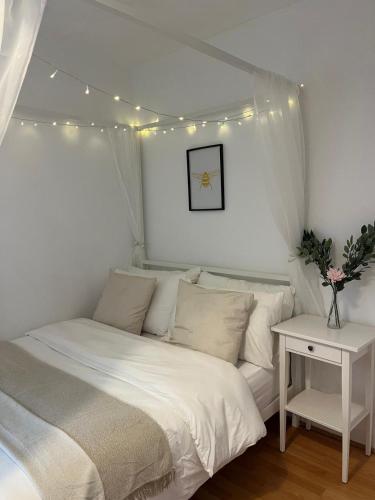 a bedroom with a white bed with lights above it at The Cotton Mill Hideaway - One Bedroom Apartment - Free Parking near Etihad Stadium & CoOp Live in Manchester