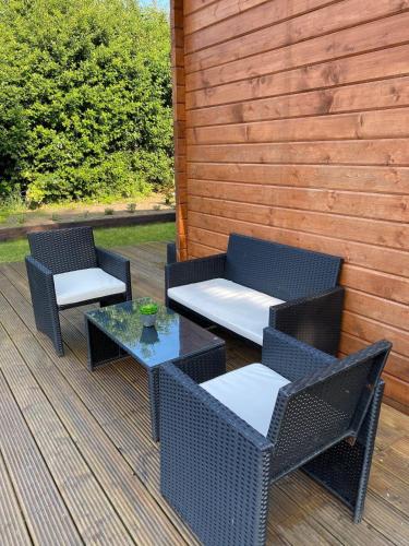 two wicker chairs and a table on a deck at Langdale Lodge in Inverness