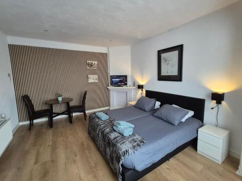 a bedroom with a bed and a table in it at Studio Slijterij Zandvoort in Zandvoort