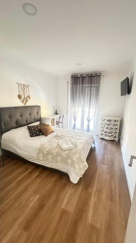 a bedroom with a large bed and a wooden floor at Alojamento Numara in Setúbal
