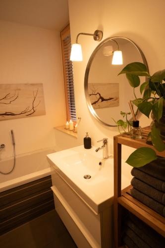 a bathroom with a sink and a mirror and a tub at An der Kirchtreppe in Blankenburg