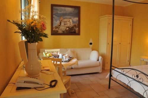 a living room with a couch and a table with a phone at Hotel Villa Del Parco in La Maddalena