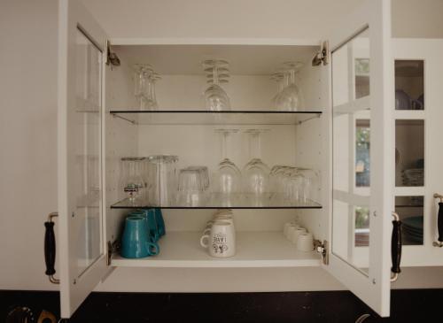 a cabinet filled with glasses on shelves in a kitchen at Huis Elsje in Emst
