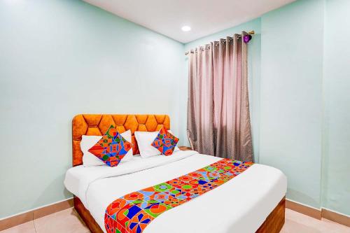 a bedroom with a bed with a colorful blanket on it at Via Emara Inn - Lalbagh Botanical Garden in Bangalore