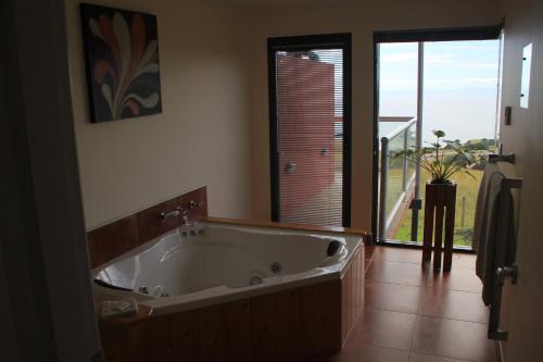 baño con bañera grande y ventana en Black Rock Retreat en Howth