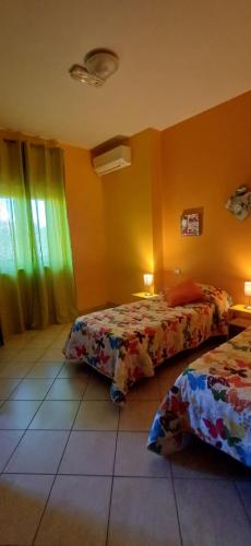 a room with two beds in a room with yellow walls at Bed & Breakfast Valeri in Artena