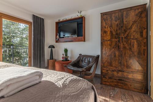 a bedroom with a sliding barn door and a tv at Apartamenty Baj na Polnej - bezpłatny parking, widok na góry i zewnętrzna balia! in PyzÃ³wka