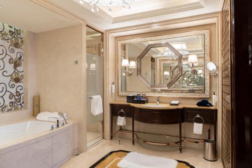a bathroom with a tub and a large mirror at Wanda Realm Harbin Hotel in Harbin