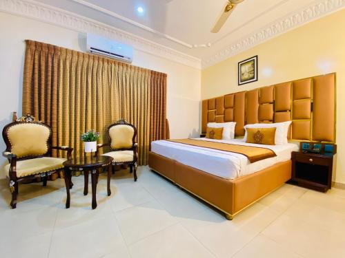 a hotel room with a bed and a table and chairs at World Inn by WIH in Karachi